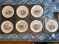 Full set of eight Darceau-Limoges collectible plates in original foam packaging, showing front decorated surfaces with historical scenes.
