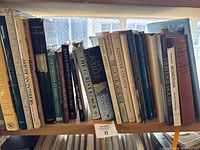 Photo showing a row of hardcover books on architecture and interior decoration including visible titles like 'The Great American House' and 'American Interiors'