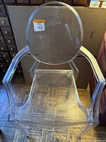 Front view of clear polycarbonate chair showing round back and armrests