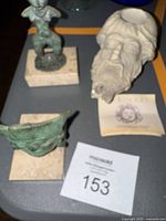 Overall view of the three sculptures including the Mayan mask, woman figure, and ceramic Carthage sculpture.