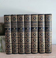 Front view showing spines of all 7 books in a row with gold embossed title 'Journeys Through Bookland' and author 'Sylvester'.