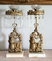 Front view of both candle holders showing overall design, marble bases, bobeches, and hanging prisms
