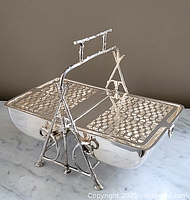 Front view with hinged pierced lid open showing warming chamber and twig style stand