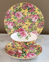 Front view of tea trio with teacup on saucer, side plate behind, showing floral pattern