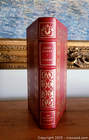 Front spine and cover view showing the deep red leather and detailed 22 karat gold decorations with raised hubs on spine