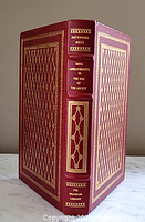 Front and spine view of the maroon leather bound book with gold decorative patterns and raised spine hubs.