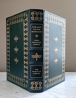 Front cover, spine, and back cover showing dark green leather with 22 karat gold embossed decorative design and text.