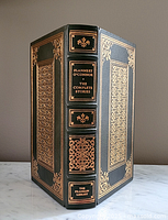 Full front and spine view of dark green leather bound book with 22 karat gold decorations.