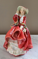 Front view showing detailed face, bonnet, red dress, and ruffled underskirt