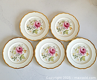 Overhead view of five 6-inch decorative floral plates showing pink rose and gold scalloped edges