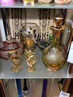 Full view of glassware shelf with decanter, glasses, vase, and candy dishes arranged together