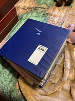 Blue binder holding a large stack of comics, showing general storage and condition.