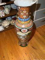 Full view of the large porcelain vase showing decorative floral patterns, wide flared rim, and colors