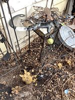 Photo of the tall metal plant stand/stool with decorative small metal flower and mouse near the base.