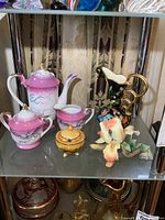 Group shot of whole lot with porcelain tea set pieces, vases, condiment dish, and Capodimonte figurine visible