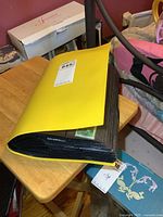 Photo of a black binder closed on a wooden table containing vintage matchbook covers.