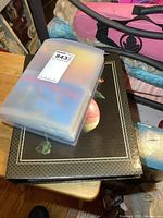 Two binders stacked, top one showing plastic sleeves filled with postcards.