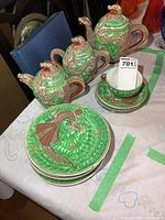 Full set including teapot, cream, sugar, cup and saucers, and snack plates showing green and red ornate dragon designs.