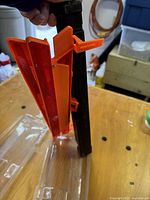 Folded orange and red reflective warning triangle showing foldable panels with plastic hinge and base.