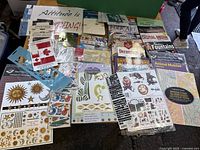 Overview photo showing variety of craft books laid out alongside stencils, thematic stickers, and transfer sheets on a flat surface.