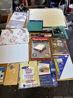 Overview of various specialty papers, envelopes, business cards, laminating pouches and other crafted papers with office supplies in containers