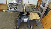 Front and side view of the vintage table saw showing motor, blade, fence and side lattice work extension support table.
