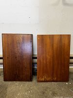 Top sides of two rectangular wooden wall shelves showing natural wood grain and finish.