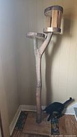 Full view of the tall wooden cat tree showing base and two levels with natural wood finish