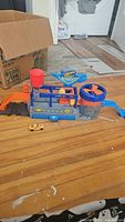 Full view of the Hot Wheels Mega Carwash playset and included color changing car on a wooden floor.