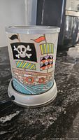Close-up of wax warmer showing pirate ship with flags and ocean waves design on glass