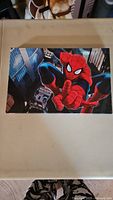 Front view of Spiderman canvas print showing character in classic pose with city buildings in the background.