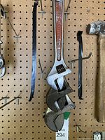 Three adjustable wrenches hanging on pegboard. One marked RASTALL S12 with worn orange paint inset.