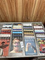 Wide view of 80 'Book of Life' magazine issues laid out on a table showing covers and arrangement in rows.