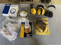 Overview of all items including ear protectors, dust masks, and gloves on a table