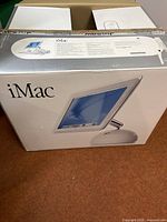 Sealed original Apple iMac G4 box exterior with product image and ‘iMac’ branding on front.