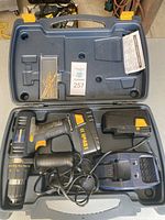 Open blue carrying case with Mastercraft 18V cordless hammer drill, battery, charger, and drill bits.