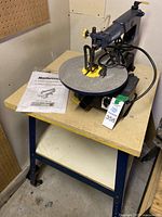 Full view of the Mastercraft scroll saw on the attached bench including instruction manual and power cord.