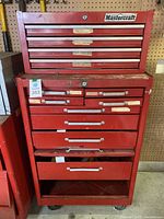 Front view of red Mastercraft two-piece tool chest on casters against pegboard background