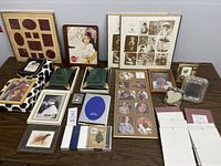Overview photo showing multiple picture frames in different sizes and styles arranged on a table, along with coaster sets in original packaging.