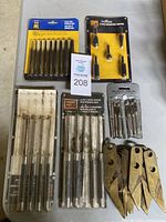 Top down view showing four sets of metal punches and a 5-piece sharping cutter set in blister packaging.