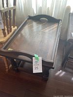 Wooden side table with removable tray placed on top, showcasing the handles and dark stained wood.