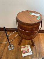 Full view of vintage barrel wooden sewing box on floor next to metal sewing hemmer and mouse-themed napkins.