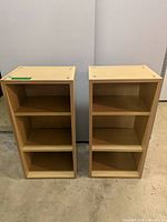 Front view of the two wooden bookshelf units side by side. Each unit has three shelves and a natural wood finish.