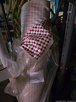 Four rolls of fabric with poker card suit patterns in plastic wrapping onsite
