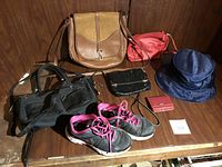 Image shows the full collection of purses, handbag, small red purse, beaded evening bag, red wallet, sneakers, and navy blue hat arranged on a wooden surface.