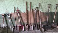 Full view of all shovels leaning against wall
