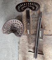 overview showing two steel tractor seats and seed planter