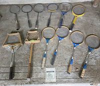 Top-down view of twelve rackets, two presses, rules booklet