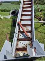 Close view of conveyor trough showing chain and slats