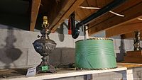 Full view showing antique Titus metal oil lamp next to a green Mid-Century Modern fiberglass lamp shade